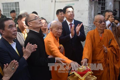 Attaching Vietnamese nameplate to Vietnamese pagoda in Thailand