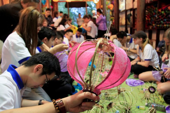 APEC delegates make decorative multi-coloured lanterns in Hoi An