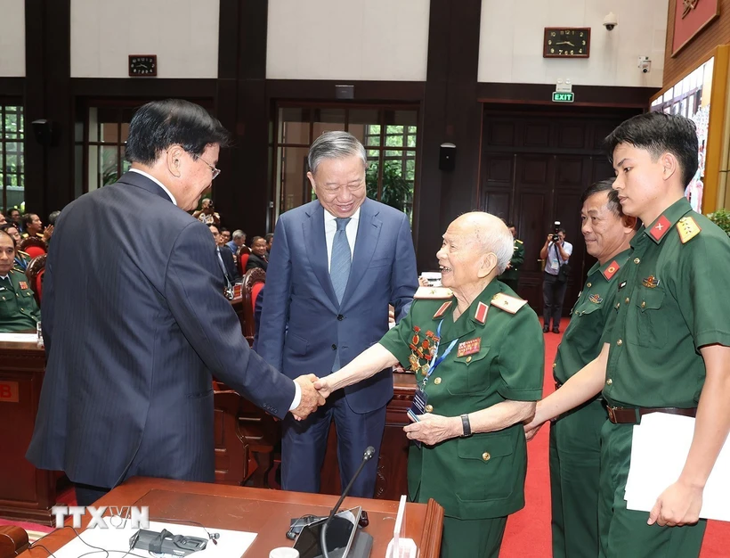 Le dirigeant lao rencontre d anciens soldats volontaires vietnamiens