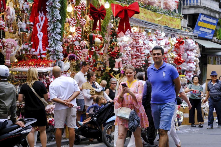 Иностранные туристы наслаждаются рождественской атмосферой на улице Хангма