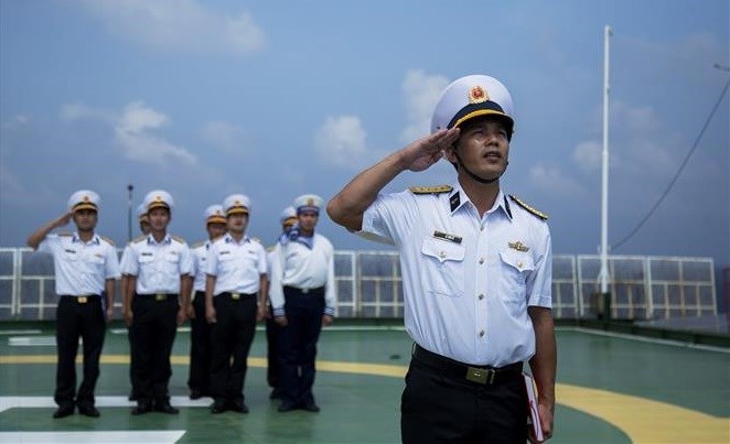Soldados vietnamitas en plataforma DK1 saludan a la bandera nacional